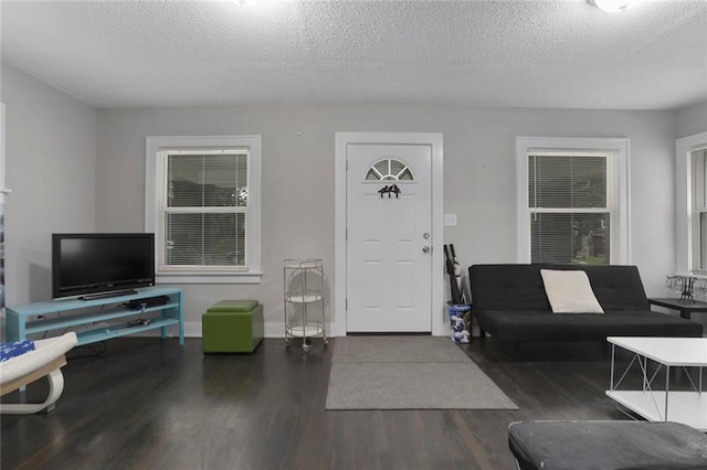 living room with a textured ceiling and dark hardwood / wood-style floors