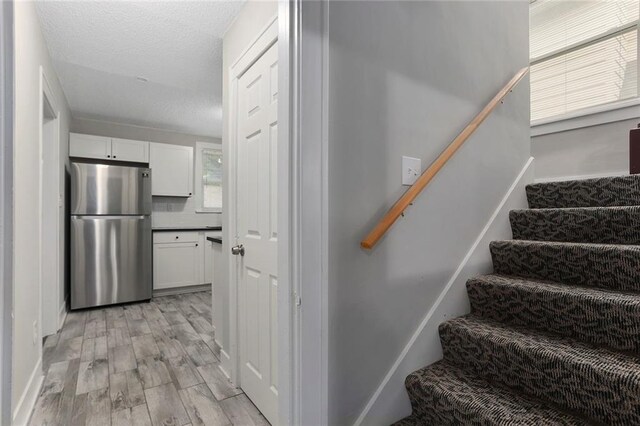 6206 Harrison St, Kansas City, MO 64110 - stairway featuring wood finished floors and a textured ceiling