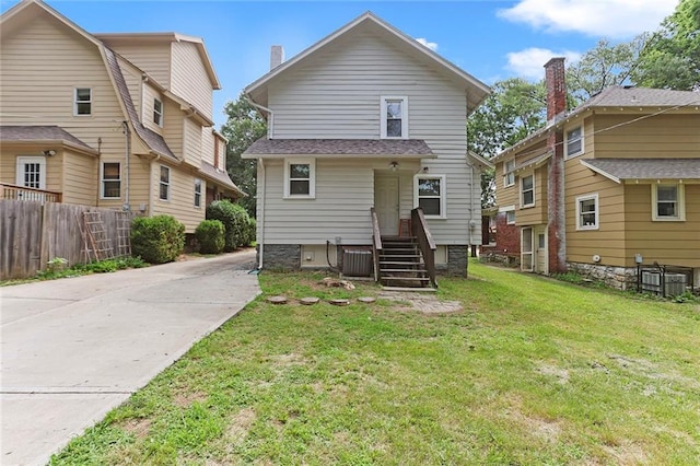 back of property featuring central AC unit and a lawn