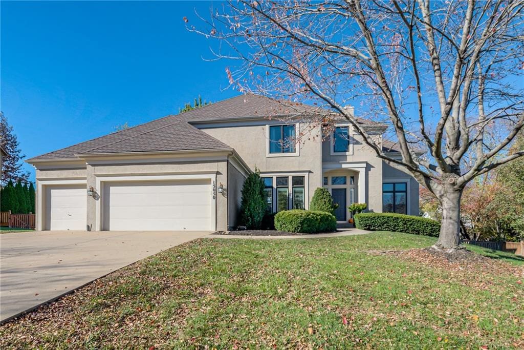 view of property with a garage and a front lawn