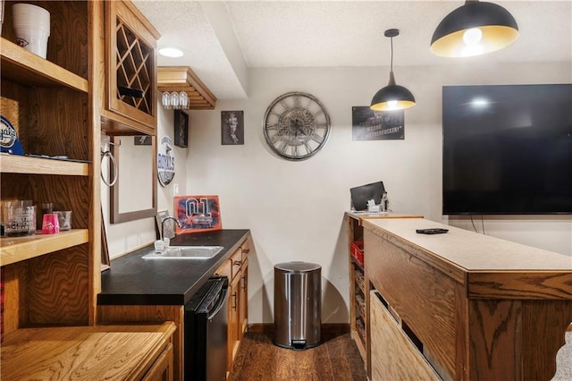 kitchen featuring hanging light fixtures, sink, black dishwasher, and dark hardwood / wood-style floors