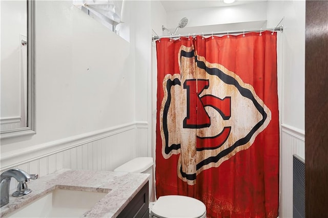 bathroom featuring walk in shower, vanity, and toilet