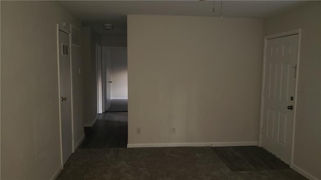 unfurnished room featuring dark colored carpet