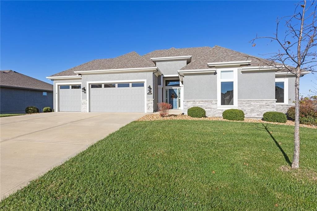 prairie-style house featuring a garage and a front yard