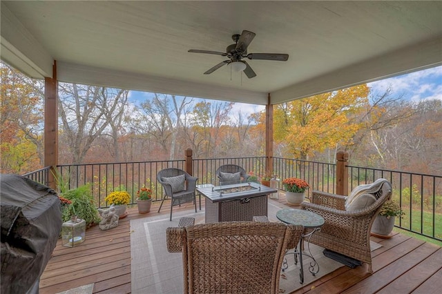 wooden terrace with ceiling fan and a fire pit