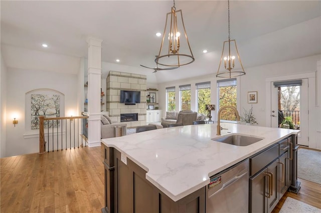 kitchen with stainless steel dishwasher, dark brown cabinetry, sink, and light hardwood / wood-style flooring