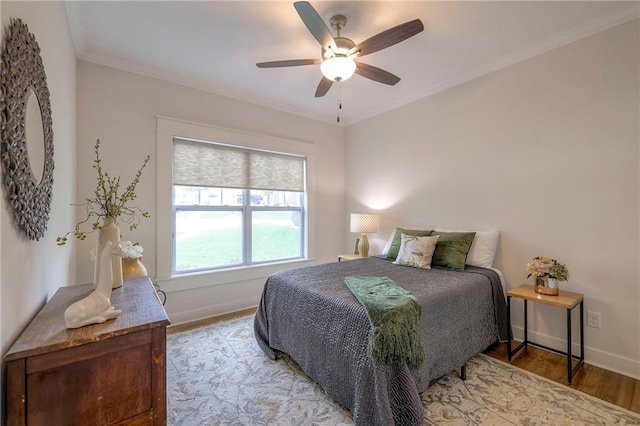 bedroom featuring light wood-type flooring, ceiling fan, and crown molding