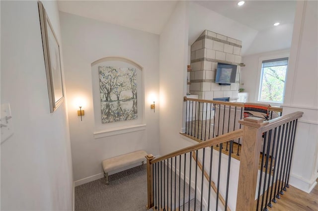 stairs with hardwood / wood-style floors and lofted ceiling