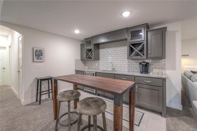 kitchen featuring gray cabinets, sink, and decorative backsplash