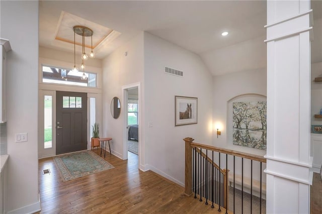 foyer entrance with wood-type flooring and a tray ceiling