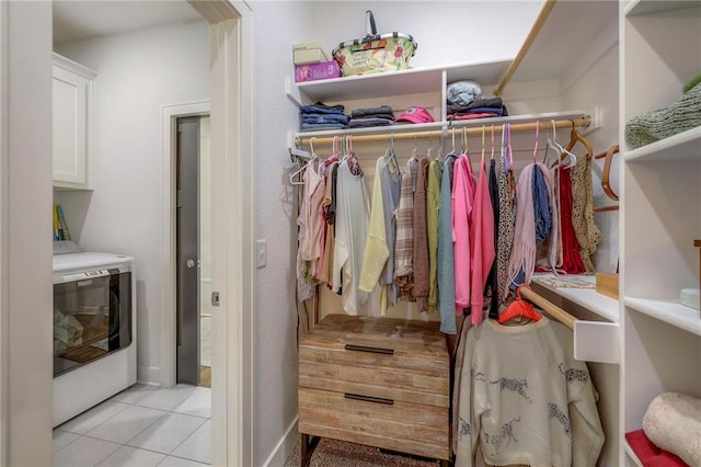 spacious closet featuring light tile patterned flooring and washer / dryer