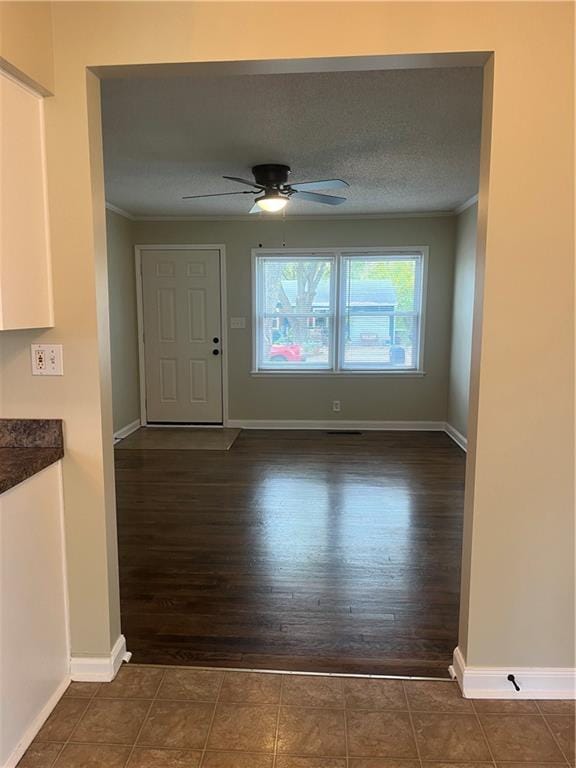 entrance foyer featuring ceiling fan, dark hardwood / wood-style floors, a textured ceiling, and ornamental molding