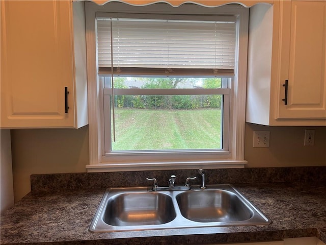 kitchen featuring white cabinets and sink