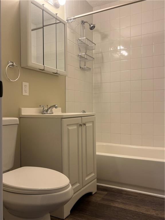 full bathroom with vanity, wood-type flooring, tiled shower / bath, and toilet