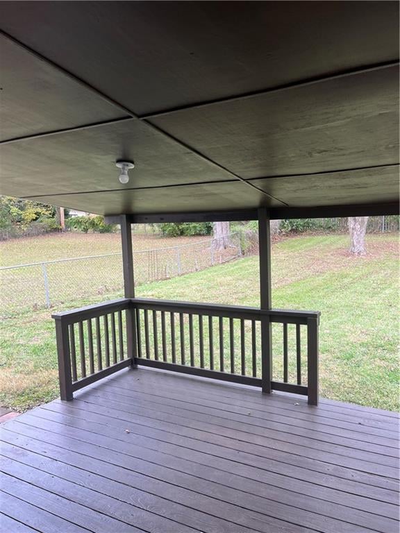 wooden terrace featuring a lawn