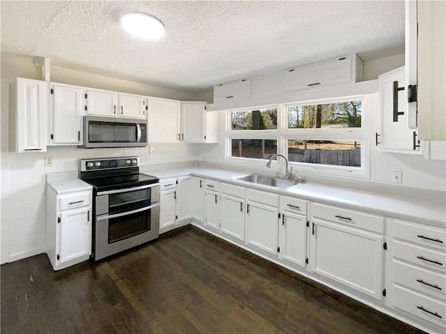 kitchen with white cabinets, stainless steel appliances, dark wood-type flooring, and sink