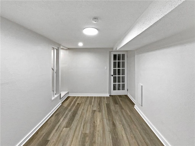 interior space with a textured ceiling, dark hardwood / wood-style floors, and a baseboard radiator