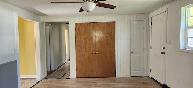 unfurnished bedroom with light hardwood / wood-style floors, ceiling fan, and two closets