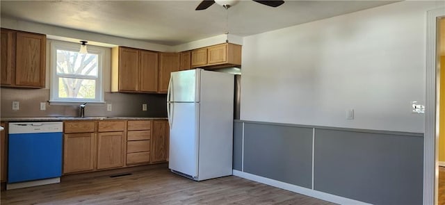 kitchen featuring light wood-type flooring, sink, white appliances, and ceiling fan