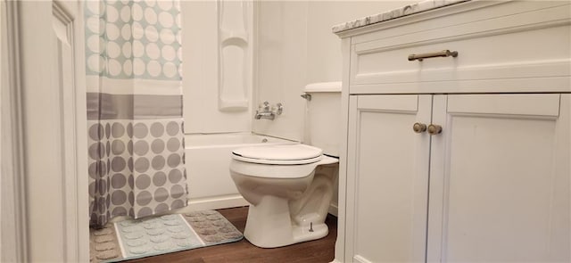 bathroom featuring shower / bath combo with shower curtain, hardwood / wood-style flooring, and toilet