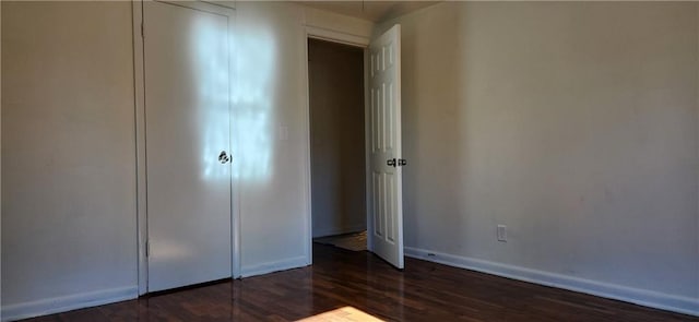 unfurnished bedroom featuring a closet and dark hardwood / wood-style floors