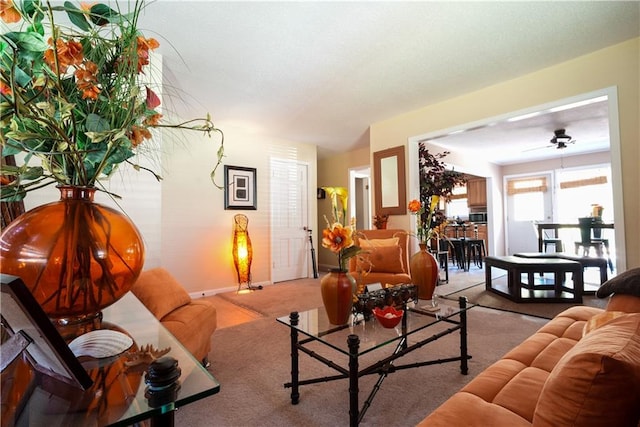 carpeted living room with ceiling fan