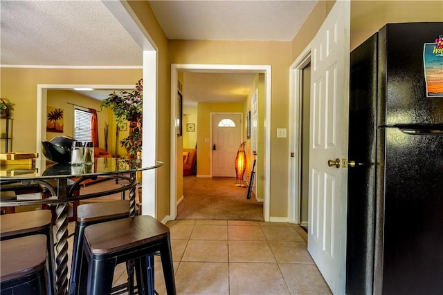 corridor featuring a textured ceiling and light tile patterned flooring