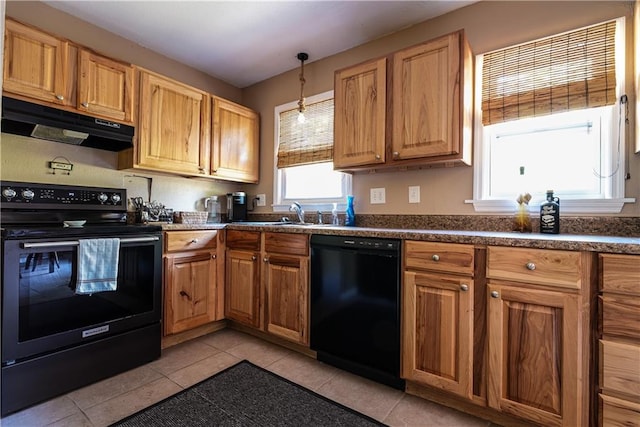 kitchen featuring sink, light tile patterned flooring, black appliances, and decorative light fixtures