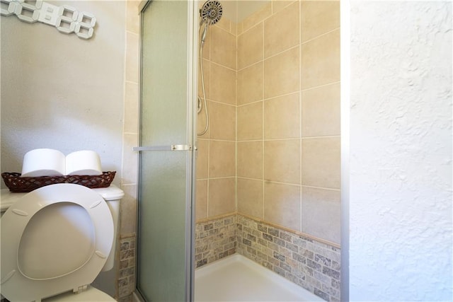 bathroom featuring an enclosed shower and toilet