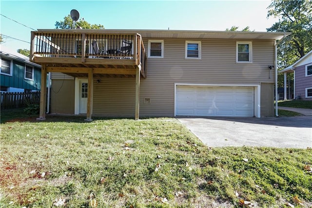 rear view of property featuring a lawn, a garage, and a deck