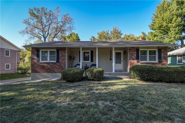 ranch-style home featuring covered porch and a front lawn