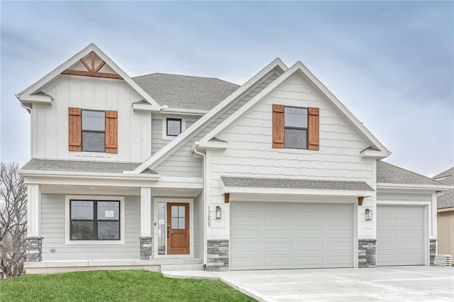 craftsman inspired home with a garage and a front lawn