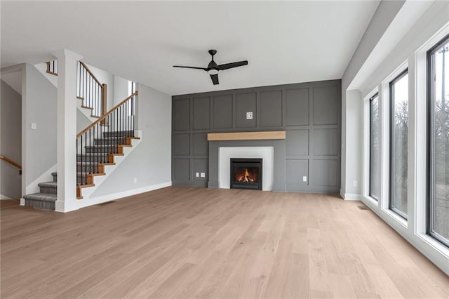 unfurnished living room featuring ceiling fan and light hardwood / wood-style flooring