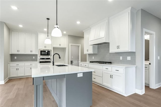 kitchen featuring white cabinetry, sink, an island with sink, and appliances with stainless steel finishes