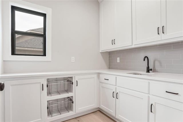 laundry room featuring sink and light wood-type flooring