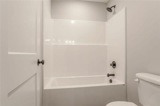 bathroom with bathing tub / shower combination and toilet