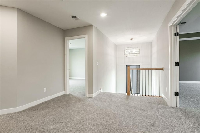 corridor with an inviting chandelier and carpet flooring