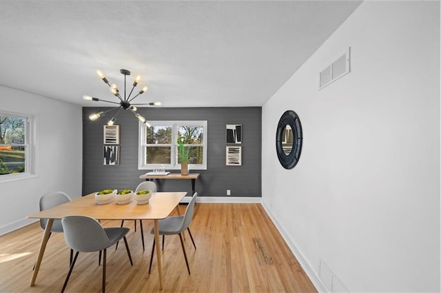 dining space featuring plenty of natural light, a chandelier, and light hardwood / wood-style flooring