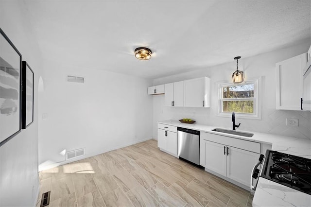 kitchen with gas stove, white cabinetry, decorative light fixtures, sink, and dishwasher