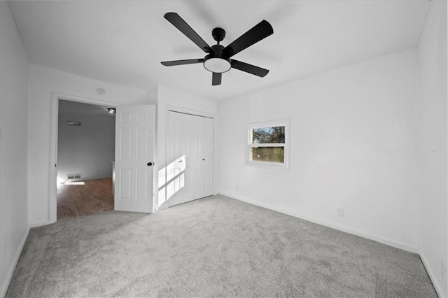 unfurnished bedroom with carpet floors, ceiling fan, and a closet