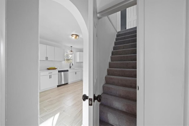 stairs with wood-type flooring and sink