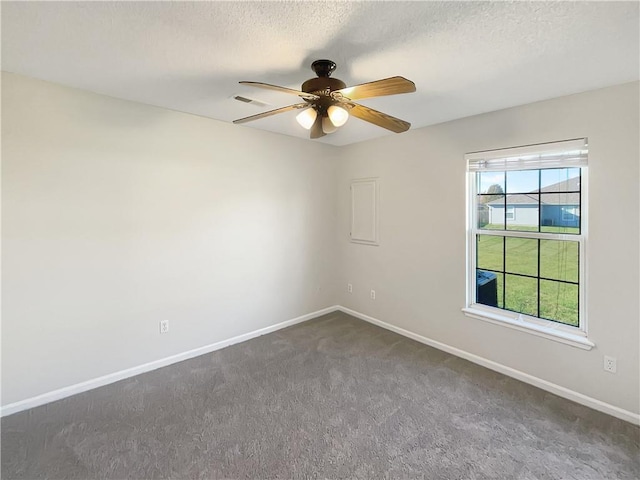 carpeted spare room featuring a textured ceiling and ceiling fan