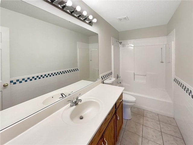 full bathroom featuring toilet, vanity, tile walls, and tile patterned flooring