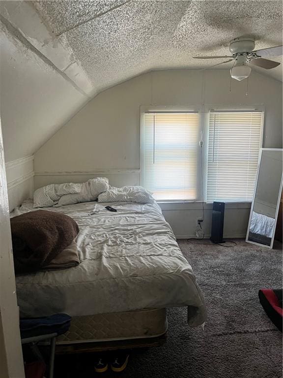 bedroom with carpet, a textured ceiling, lofted ceiling, and ceiling fan