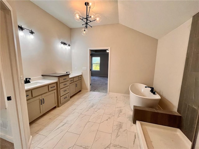 bathroom with a chandelier, vanity, vaulted ceiling, and a bathtub