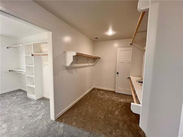 walk in closet featuring dark colored carpet