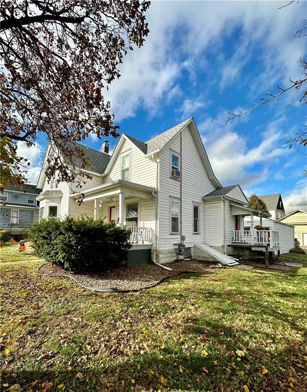 back of property featuring a lawn and a deck