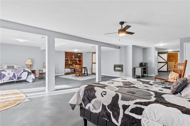 bedroom featuring heating unit, ceiling fan, and concrete floors