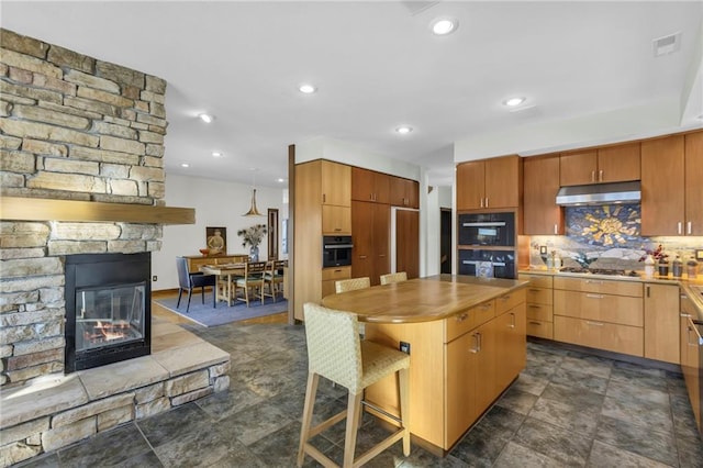 32225 W 88th St, De Soto, KS 66018 - kitchen featuring oven, stainless steel gas cooktop, a fireplace, and under cabinet range hood