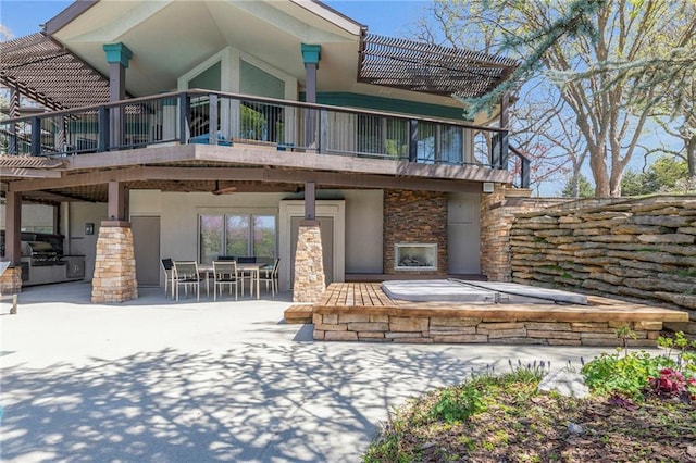 32225 W 88th St, De Soto, KS 66018 - rear view of property featuring outdoor dining space, a balcony, stucco siding, stone siding, and a patio area
